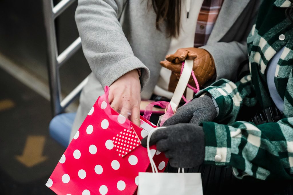 two people taking groceries and putting them in a bag