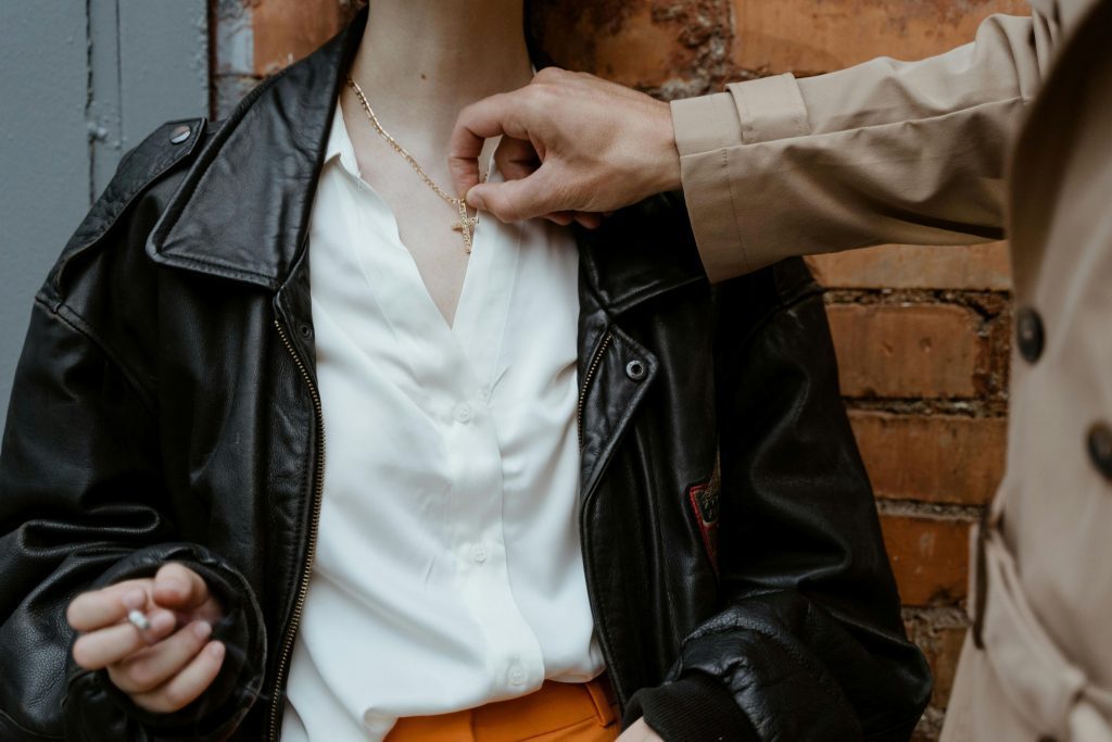 person touching necklace gently